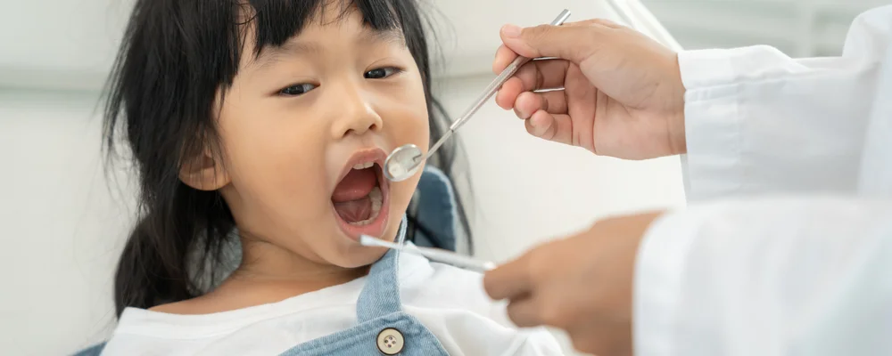 歯科医師がミラーで子どもの歯の本数を確認している様子｜アトレ五反田シティデンタルクリニック